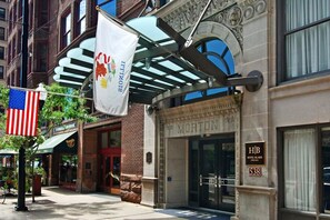 Classic hotel entrance with arched doorway and American flag.