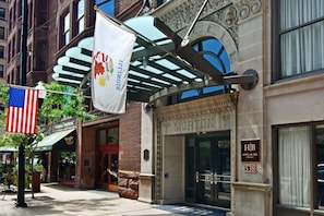 Classic hotel entrance with arched doorway and American flag.