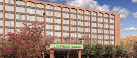 Un hotel Wyndham Garden con fachada de ladrillo, amplias ventanas y entrada cubierta.
