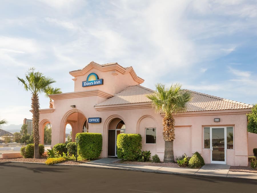A Days Inn building with a sign, office entrance, and palm trees.