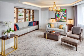 A modern living room with a sofa, armchairs, a coffee table, and a bookshelf. - Kempinski Hotel Corvinus Budapest (Budapest)