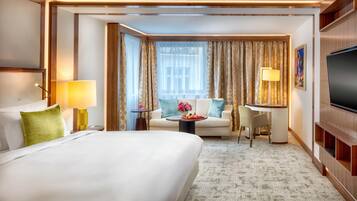 Una habitación de hotel con una cama grande, un escritorio, una silla y un televisor.