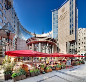 Un hotel con terraza exterior y una vista despejada de la fachada del edificio.