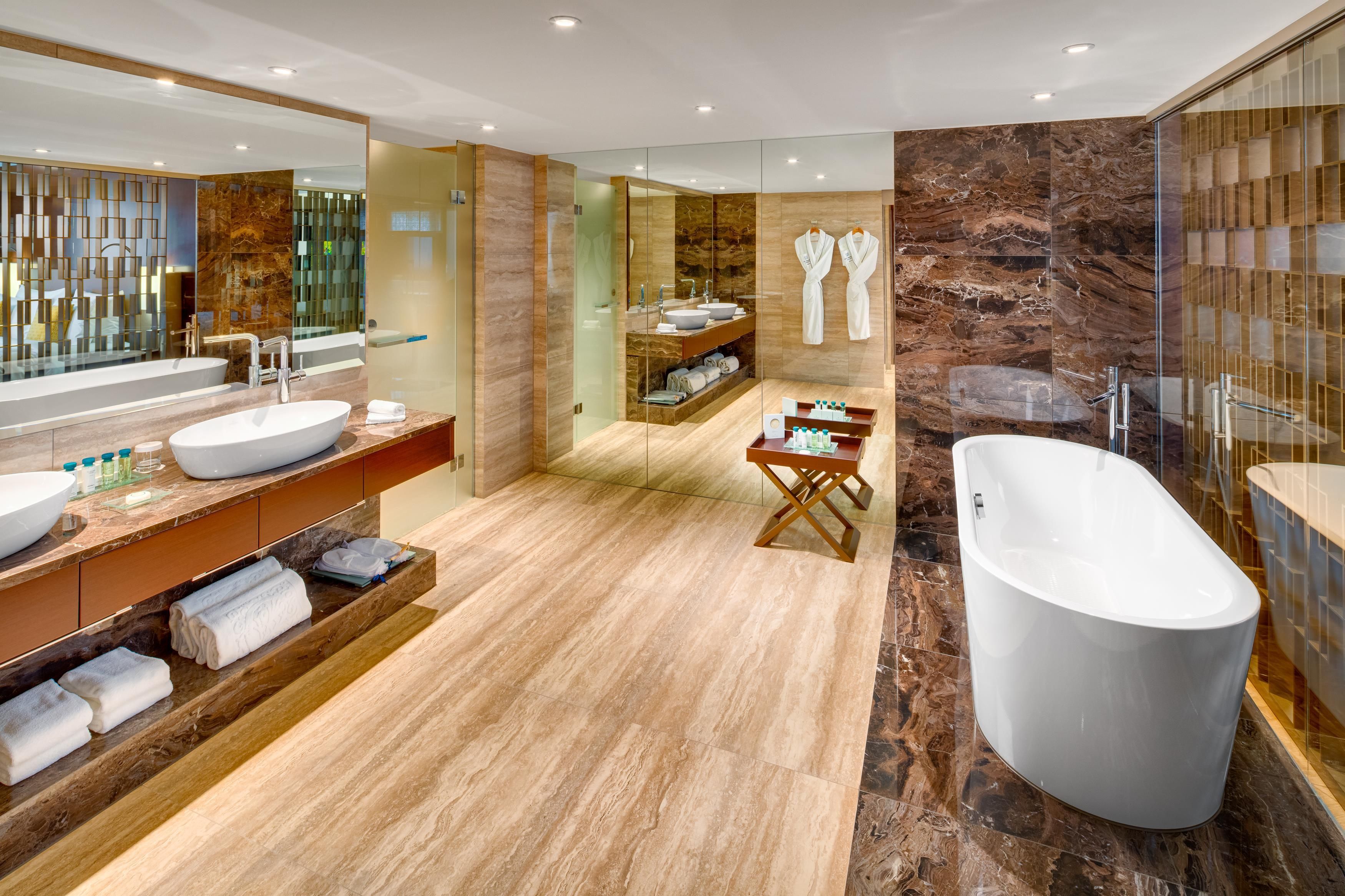 A modern bathroom with a freestanding bathtub, a large vanity with a bowl sink, and a glass-enclosed shower area.