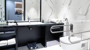 Une salle de bain moderne avec un meuble-lavabo noir, un lavabo blanc et des murs en marbre.