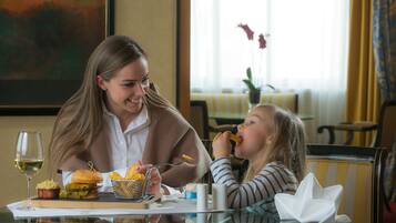 A dining table with a sandwich, chips, and a glass of wine.