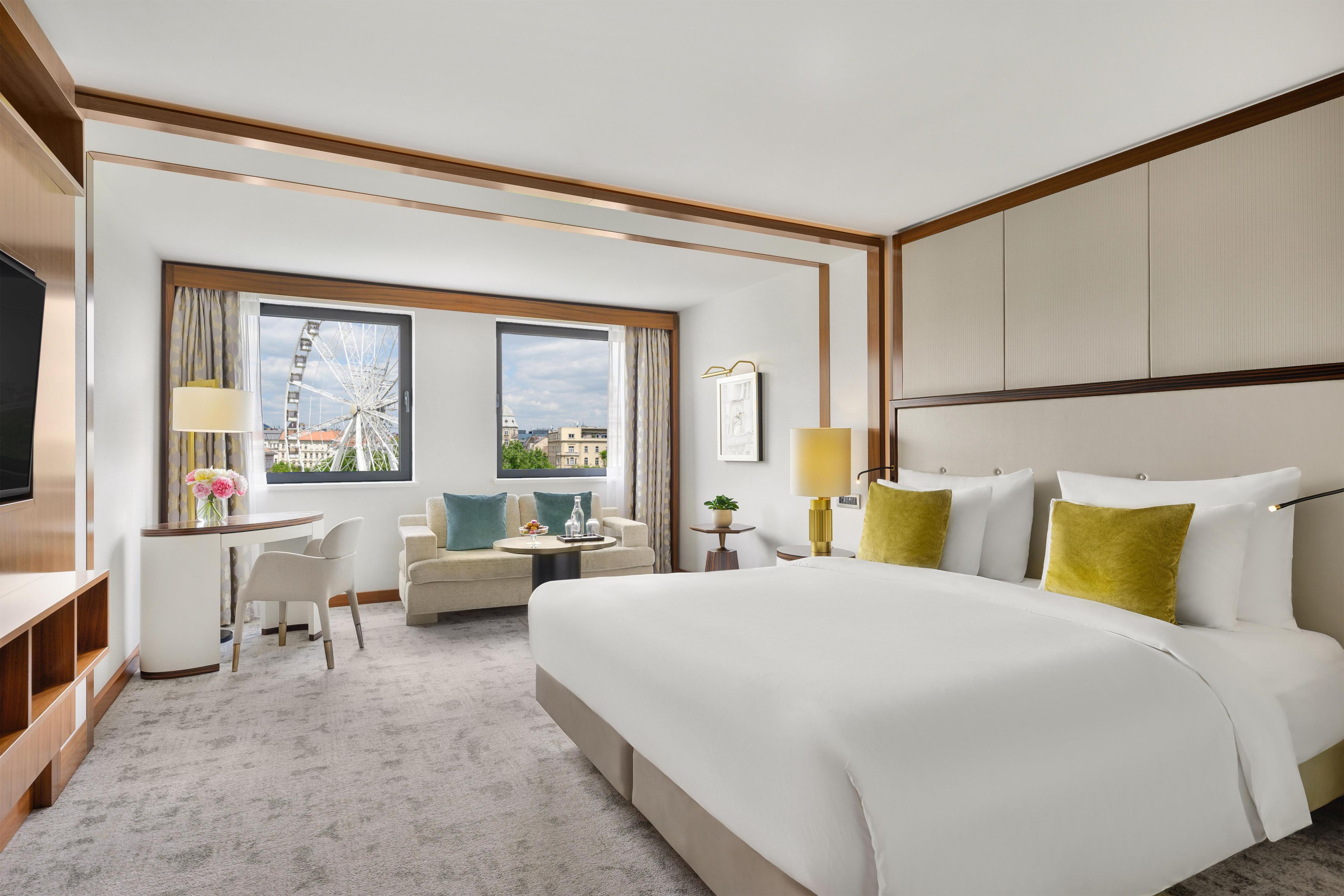 Una habitación de hotel con cama, escritorio, silla, sofá y televisión.