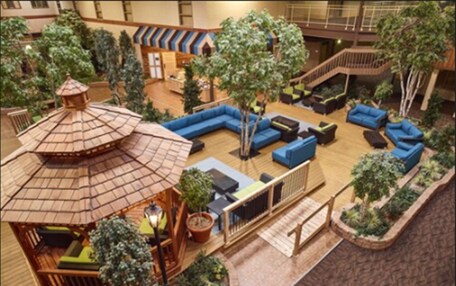An indoor atrium with a central seating area, a small gazebo, and surrounding greenery.