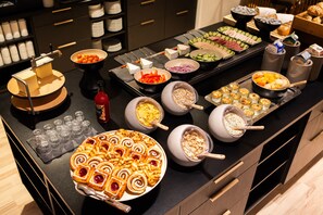 A buffet with various food items and a cheese grater.