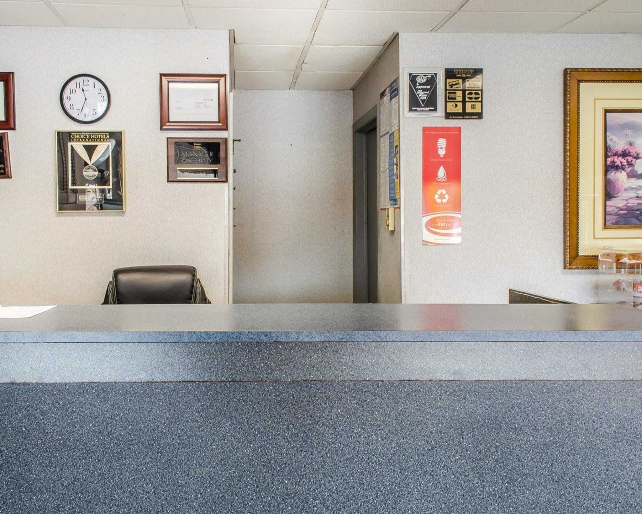 A reception area with a clock, framed awards, and a painting on the wall.