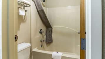 Un baño con bañera, inodoro y cortina de ducha.