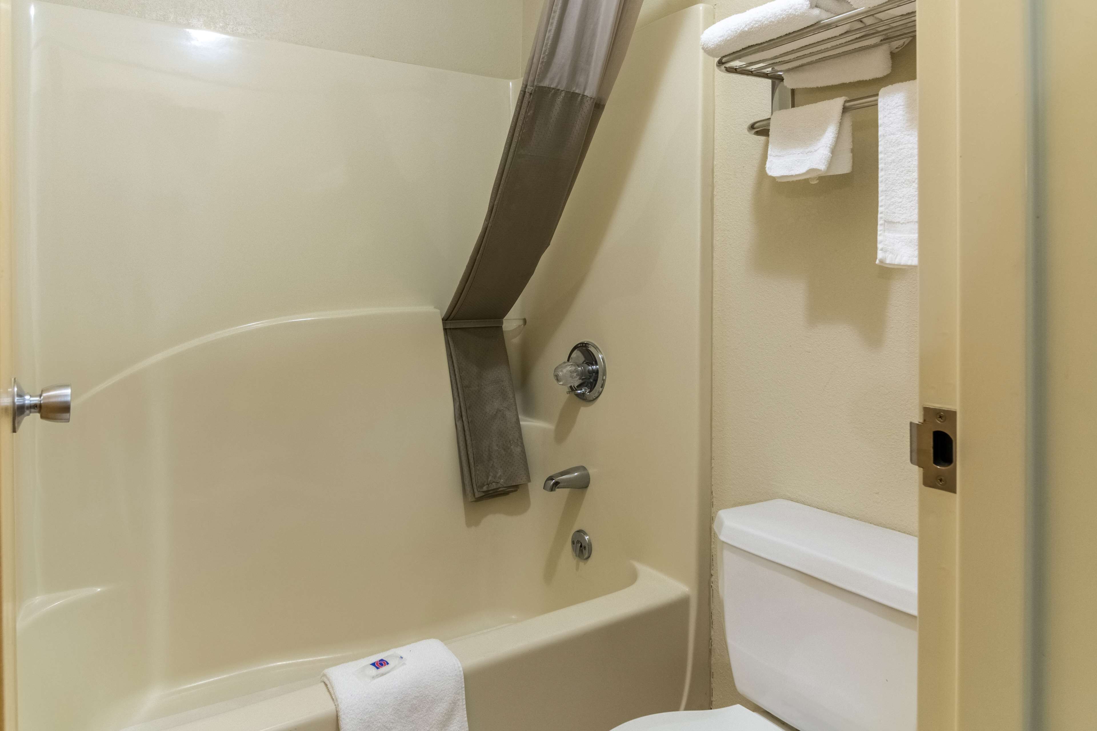 Une salle de bain avec une baignoire, des toilettes et un porte-serviettes.