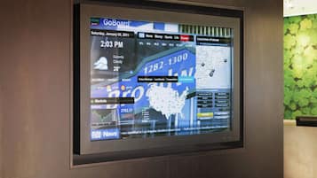 Una pantalla digital que muestra un pronóstico del tiempo, noticias y un mapa.