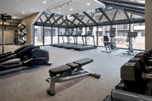 A gym with treadmills, elliptical machines, and weightlifting equipment. - Courtyard by Marriott Rye (Rye Brook)