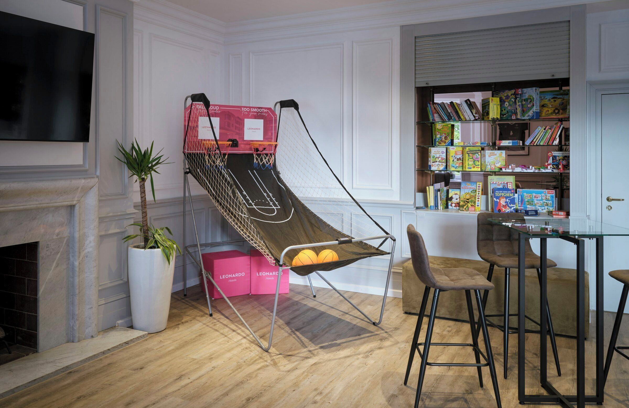Une pièce avec un hamac, une cheminée, une bibliothèque et un téléviseur.