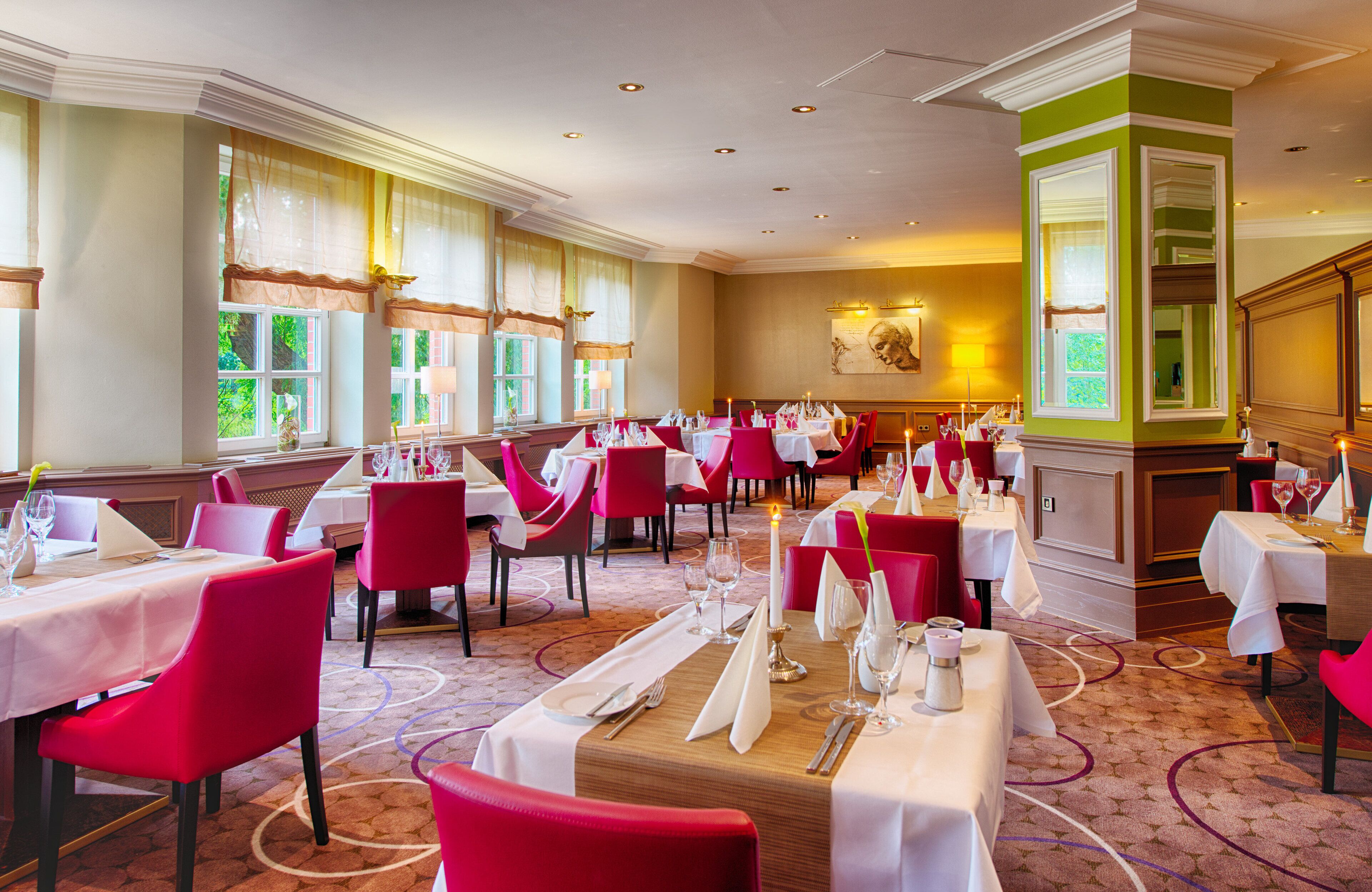 Ein Restaurant mit mehreren Tischen und Stühlen, ansprechend angeordnet in einem großzügigen Raum mit großen Fenstern und Teppichboden.