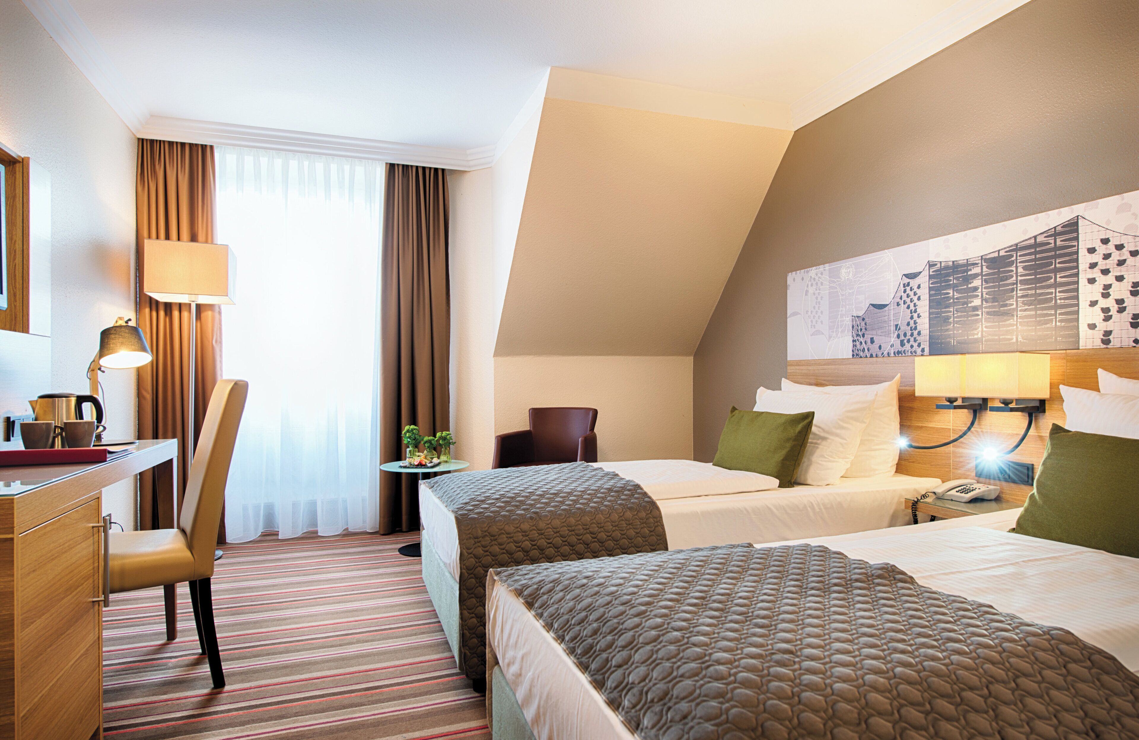 A hotel room with two beds, a desk, a chair, a lamp, and a painting on the wall.