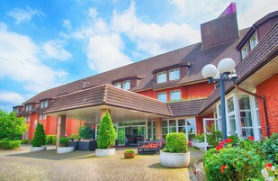 Ein Hotel mit überdachtem Außenbereich, Blumentöpfen und einer Ziegel-Fassade.