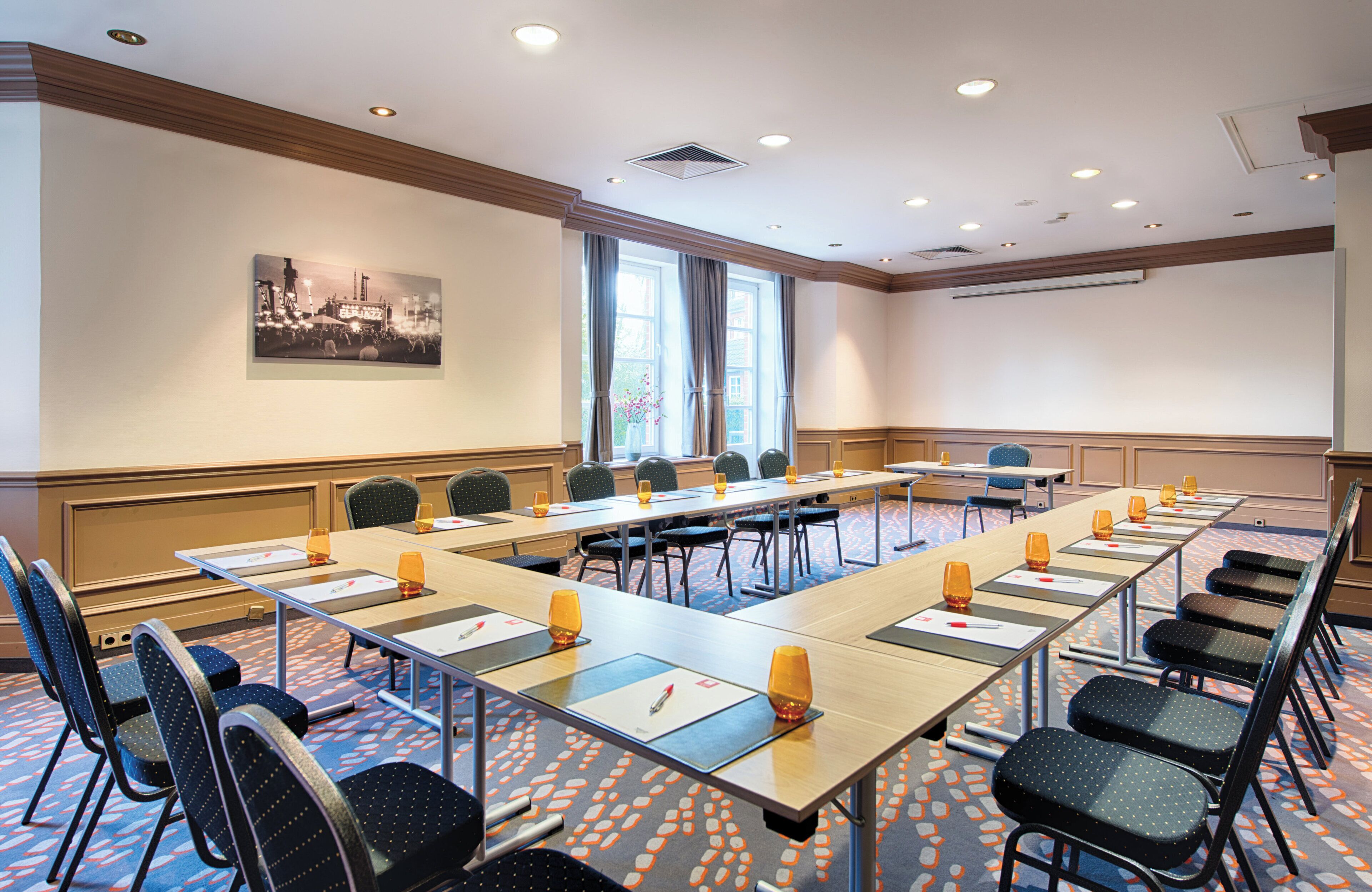 A conference room with a long table, chairs, and a projector screen.
