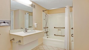 Un baño con lavamanos, espejo y bañera blancos.