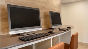 Un mostrador de recepción moderno con dos monitores, un teclado y un ratón.