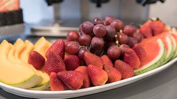 Une assiette de pastèque coupée en tranches, de fraises et de raisins.