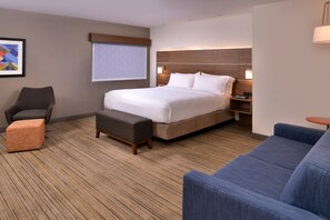 A hotel room with a large bed, a desk with a chair, a sofa, a small table, and a window with blinds. - Holiday Inn Express Walnut Creek by IHG (Walnut Creek)