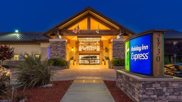 Welcome to Holiday Inn Express, featuring a modern entrance with stone pillars and a beautifully landscaped area.