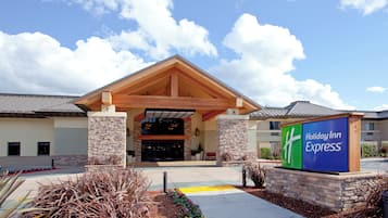 Un bâtiment de l’hôtel Holiday Inn Express avec une façade en pierre, une entrée couverte et une enseigne.