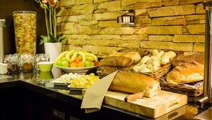Un buffet proposant une variété d’aliments, notamment des fruits, des fromages et des pains.