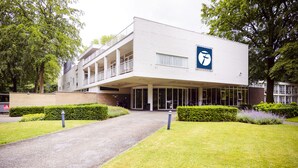 Un bâtiment moderne avec une façade blanche, de grandes fenêtres et un logo sur le côté.