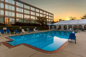 Una piscina al aire libre de temporada, sombrillas