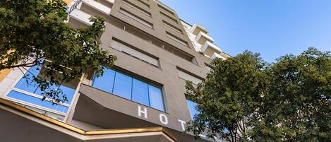 Un moderno edificio de hotel con un letrero que dice 'HOTEL', ventanas grandes y un techo plano.