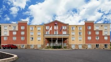 Stunning hotel with a central entrance and uniform design, featuring brick and stone detailing around windows and entrance.