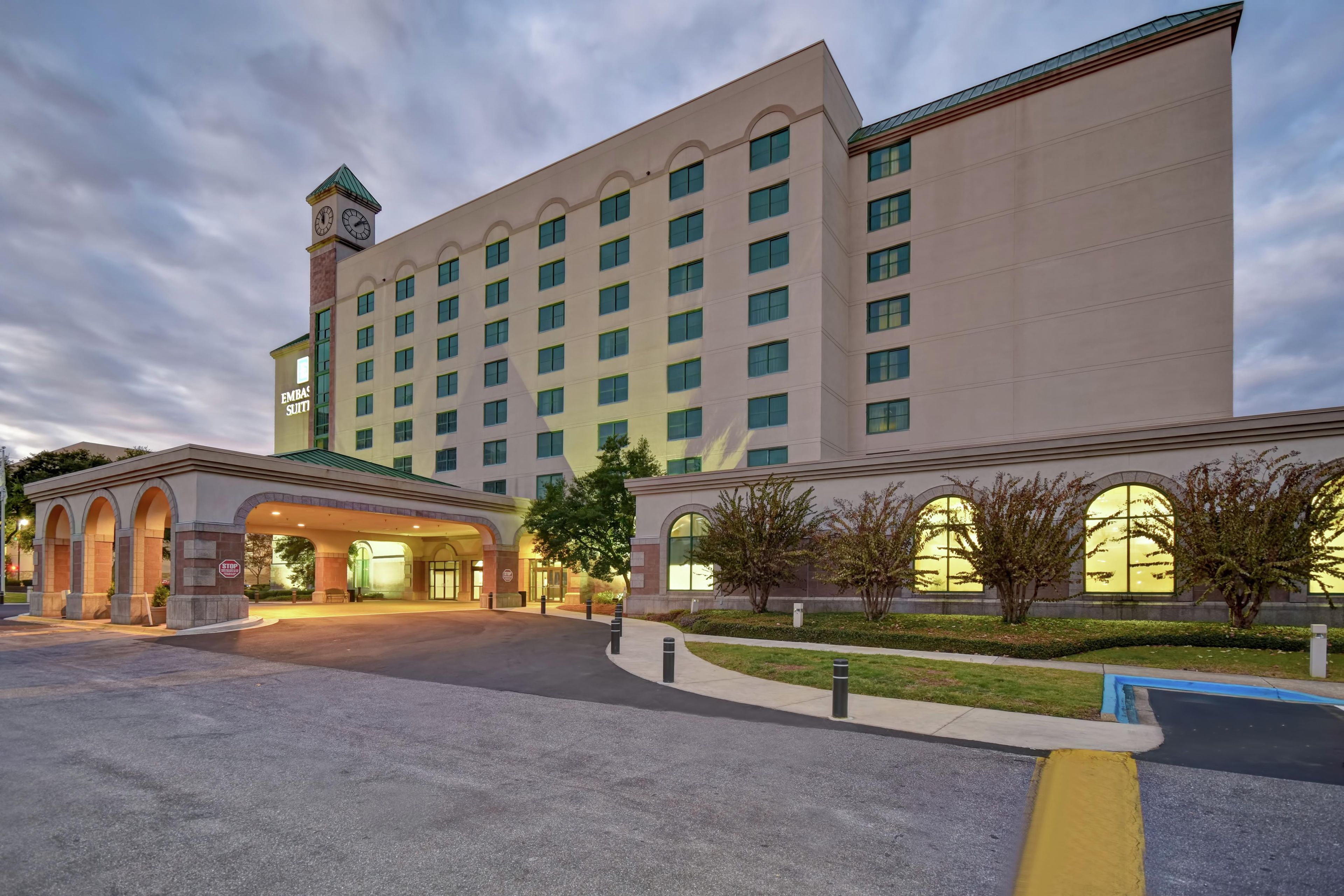 A large hotel with multiple floors, a prominent clock tower, and a well-lit entrance.