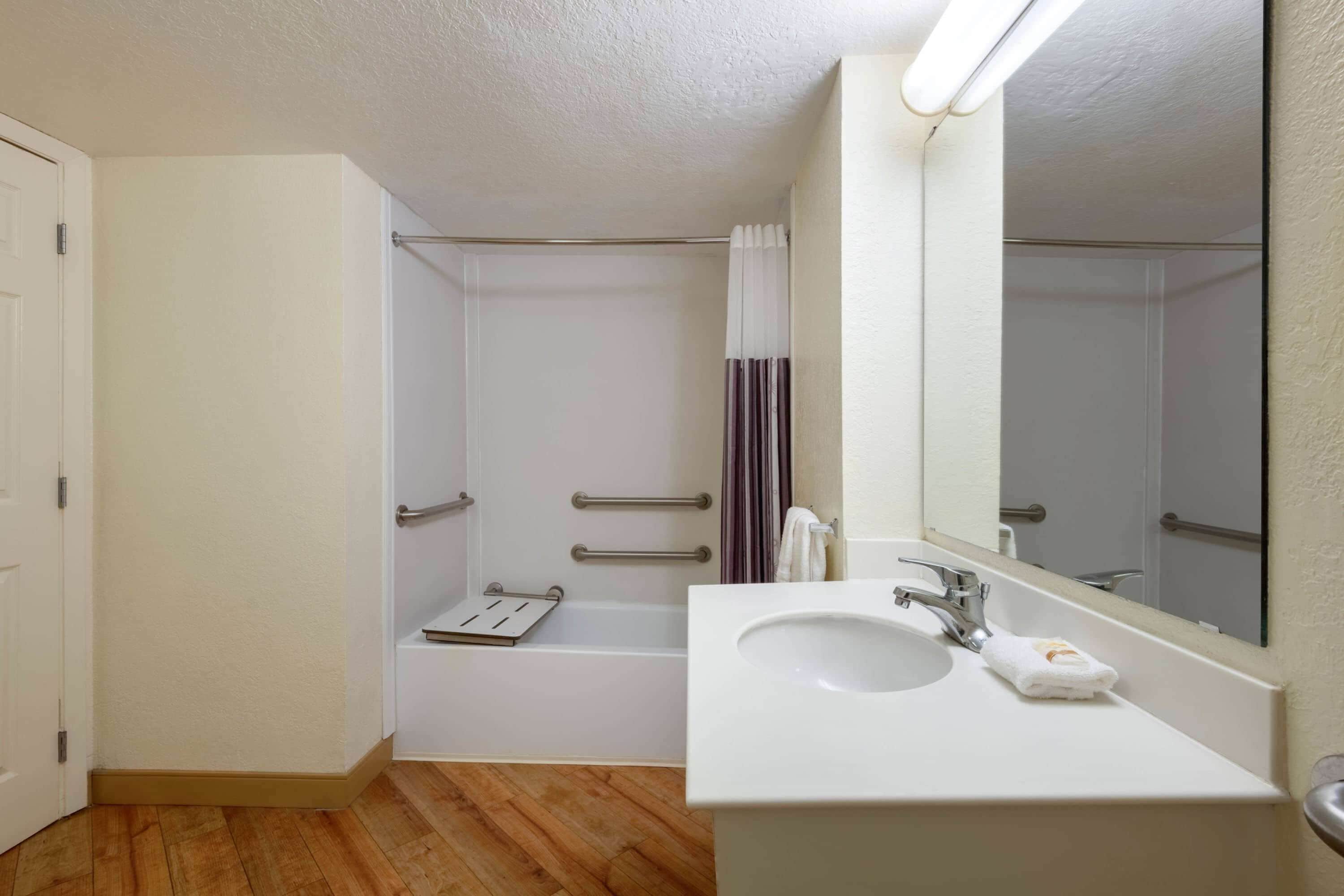 Une salle de bain avec un lavabo blanc, un miroir et un espace douche.