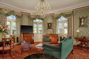 A traditional room with a chandelier, a television, and classic furniture.