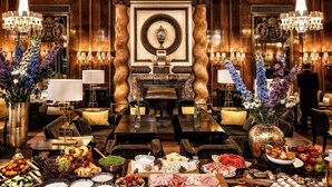 A luxurious hotel lobby with a grand fireplace, elegant chandeliers, and a variety of food and drink stations. - Hotel Bristol, a Luxury Collection Hotel, Vienna (Vienna)