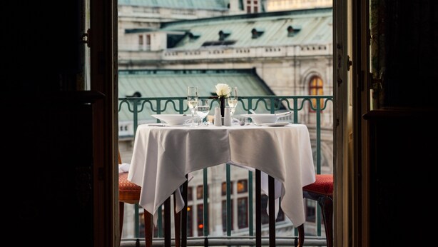 A table set for two with a view of a large building with a green dome in the background. - Hotel Bristol, a Luxury Collection Hotel, Vienna (Vienna)