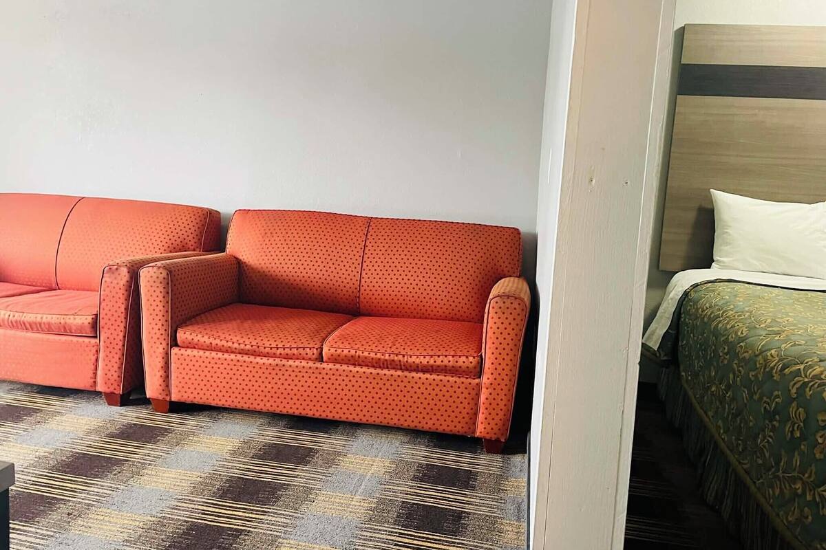 Una habitación de hotel con sofá y cama.