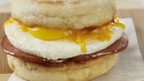 Un sándwich de desayuno sobre una tabla de madera.