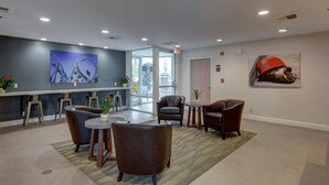 En modern entréhall med en sittgrupp, en stor målning som föreställer en berg- och dalbana och en hjälm som hänger på väggen.