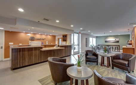 A reception area with a wooden reception desk, leather seating, and a coffee station.