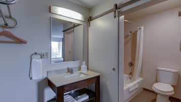 A bathroom with a sink, mirror, towel rack, and toilet.