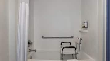 Un baño con una bañera blanca, una barra de apoyo, una cortina de ducha y un estante con artículos de aseo.