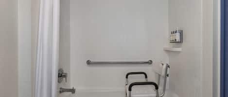 Un baño con una bañera blanca, una barra de apoyo, una cortina de ducha y un estante con artículos de aseo.