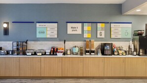 Una cocina moderna con una encimera que exhibe diversos alimentos y una pared con pizarras de menú.