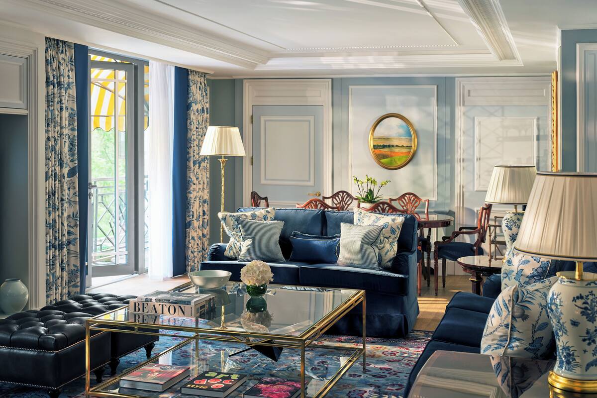 A well-appointed living room with a blue sofa, a glass coffee table, and a decorative lamp.