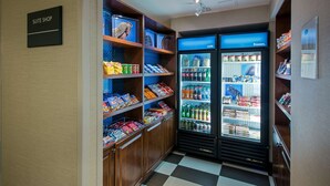 A suite shop with a refrigerated display case containing various beverages and snacks. - Hampton Inn West Springfield (West Springfield)