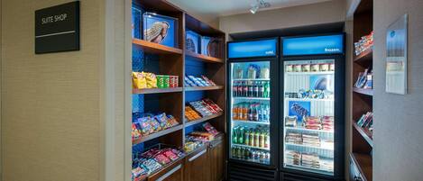 A suite shop with a refrigerated display case containing various beverages and snacks.